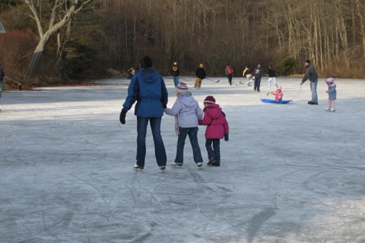 Residents ice skating on a local pond near Town Hall